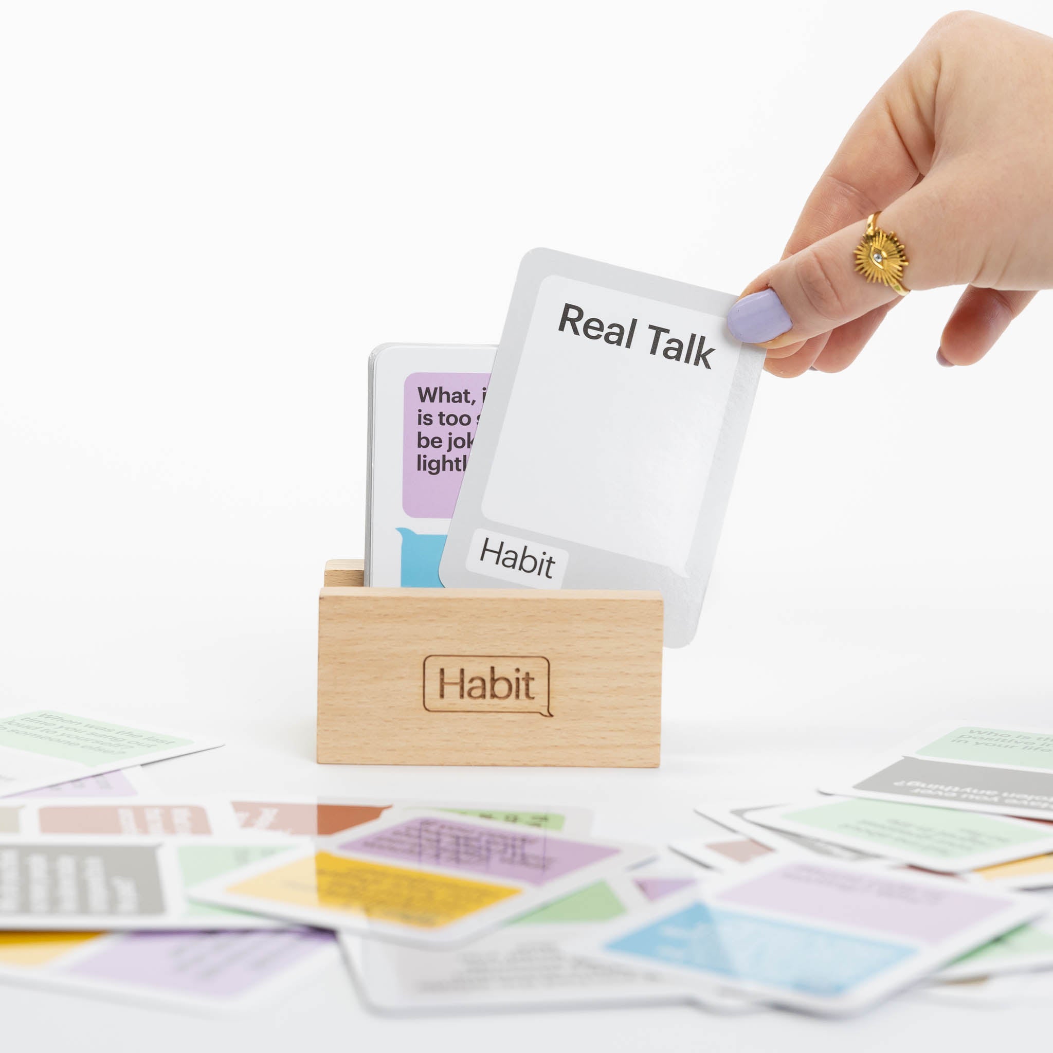 wooden stand with Real Talk card being held by woman's hand, conversation card game, Habit