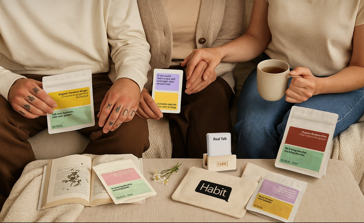 Two people sitting on a couch holding 'Habit' product packages and a coffee cup.